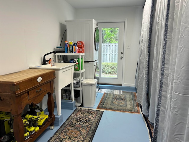 clothes washing area with stacked washer / dryer