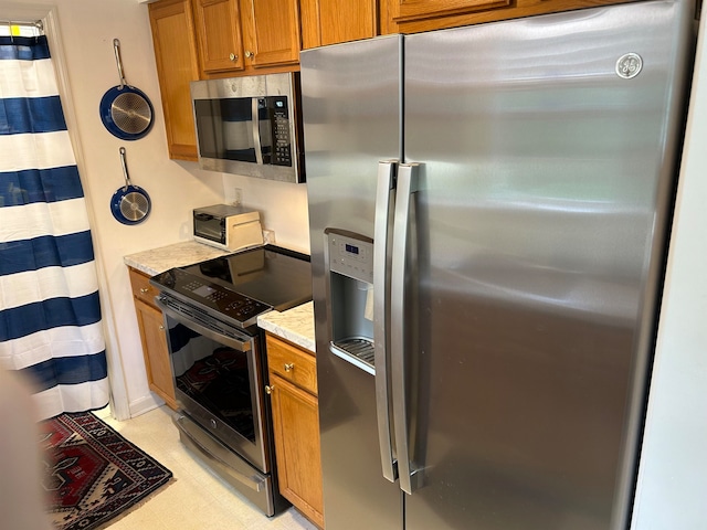 kitchen featuring light stone counters and appliances with stainless steel finishes