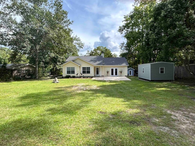 back of house featuring a shed, a lawn, and a patio