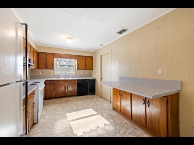 10168 NE Colin Kelly Hwy, Pinetta Madison County, FL 32350 - kitchen with brown cabinets, freestanding refrigerator, dishwasher, light countertops, and a sink