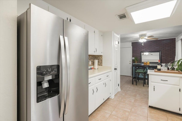 3822 Leane Dr, Tallahassee, FL 32309 - kitchen with stainless steel fridge, a ceiling fan, light countertops, light tile patterned floors, and white cabinets