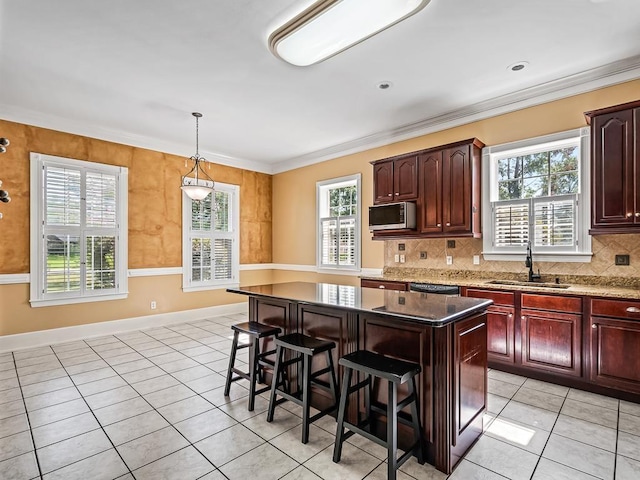 127 Bullen Ln, Perry, FL 32347 - kitchen featuring a sink, stainless steel appliances, light tile patterned floors, a breakfast bar, and a kitchen island