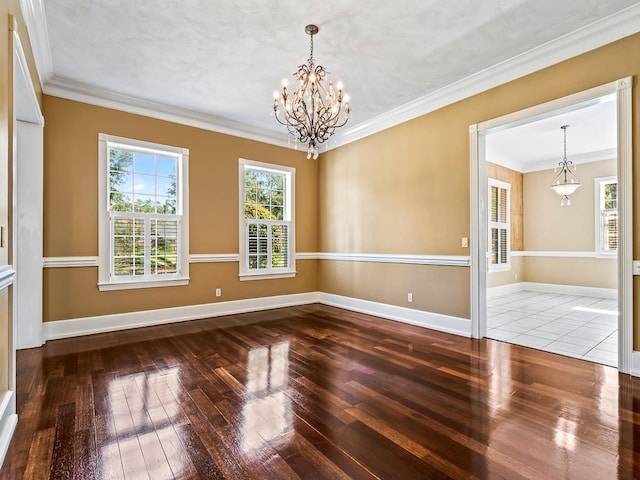 unfurnished room with wood-type flooring, a notable chandelier, and crown molding