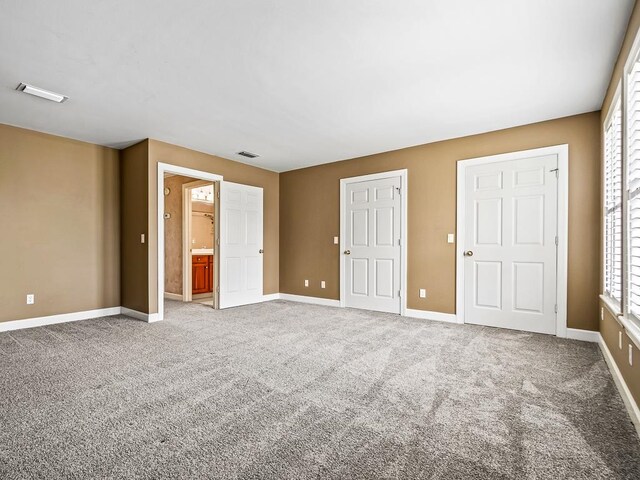 unfurnished bedroom featuring carpet flooring and ensuite bath