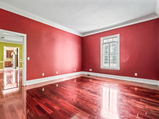 empty room featuring hardwood / wood-style floors and ornamental molding