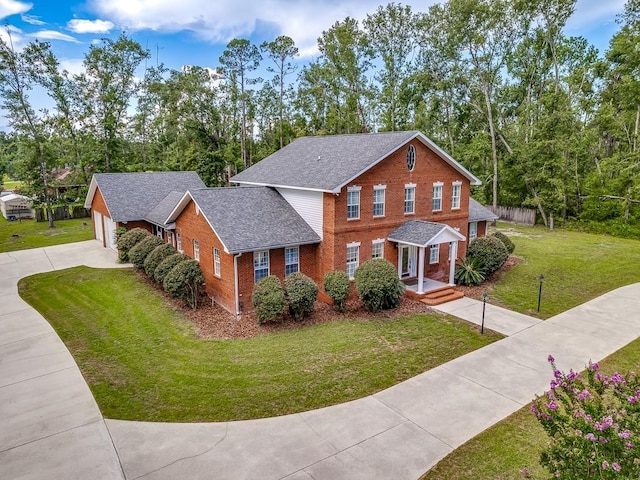 127 Bullen Ln, Perry, FL 32347 - traditional home featuring driveway, brick siding, a front yard, roof with shingles, and a garage