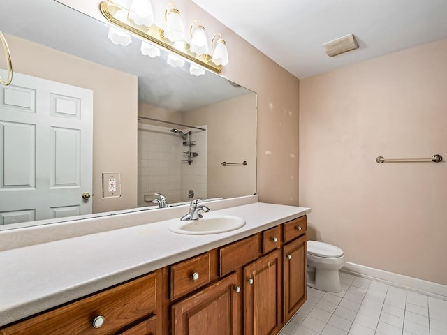 bathroom with vanity, tile patterned flooring, toilet, and tiled shower