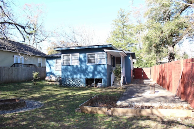 837 Dent St, Tallahassee, FL 32304 - view of front of house featuring a front yard, a patio area, a fenced backyard, and an outdoor fire pit