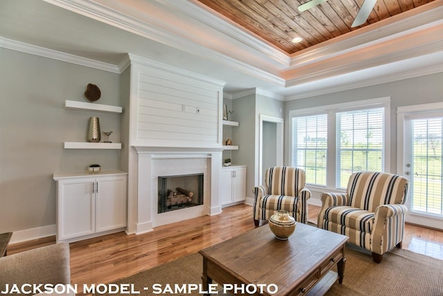 living room with built in shelves, light wood-type flooring, and crown molding