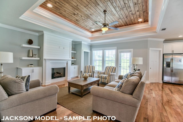 living room with built in shelves, crown molding, wood ceiling, light hardwood / wood-style floors, and a tray ceiling