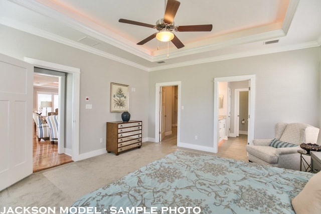 carpeted bedroom with crown molding, ensuite bath, ceiling fan, and a raised ceiling