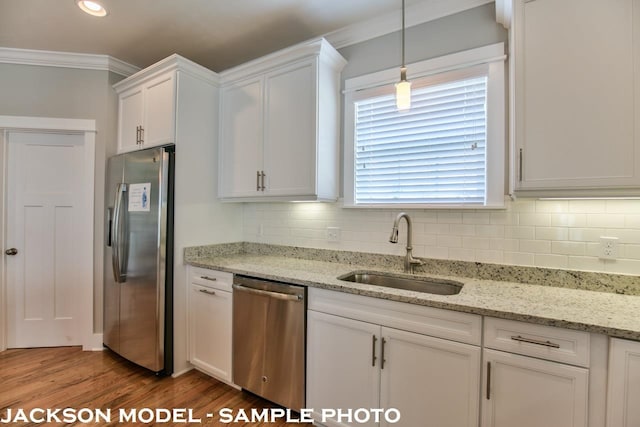 kitchen featuring stainless steel appliances, light stone countertops, hardwood / wood-style floors, sink, and white cabinets