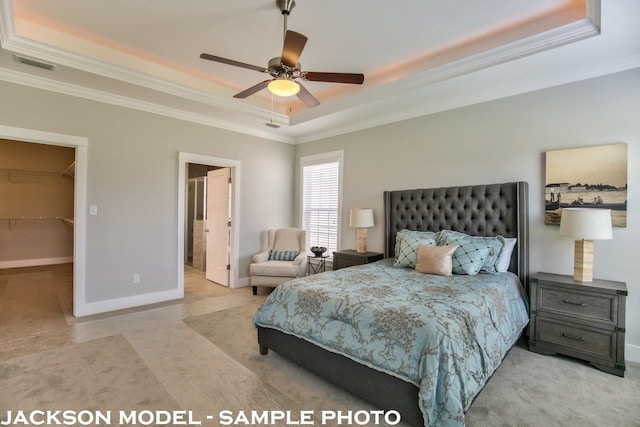 bedroom featuring a closet, a spacious closet, crown molding, a raised ceiling, and ceiling fan