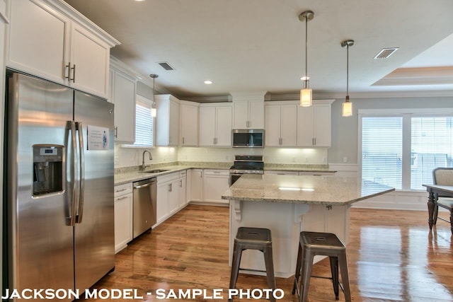 kitchen featuring white cabinets, a wealth of natural light, appliances with stainless steel finishes, and light hardwood / wood-style flooring