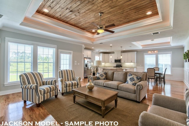 living room with wooden ceiling, light hardwood / wood-style floors, a raised ceiling, and ornamental molding