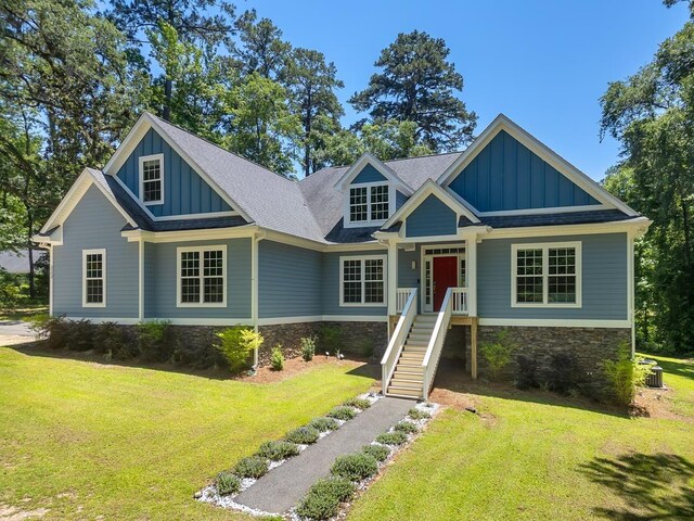 323 Carr Ln, Tallahassee, FL 32312 - craftsman-style home with board and batten siding, stone siding, a front lawn, and roof with shingles