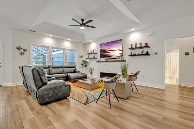 323 Carr Ln, Tallahassee, FL 32312 - living area featuring a raised ceiling, a ceiling fan, light wood-style floors, a lit fireplace, and recessed lighting