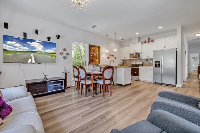 323 Carr Ln, Tallahassee, FL 32312 - living area with light wood-style floors, a chandelier, and recessed lighting