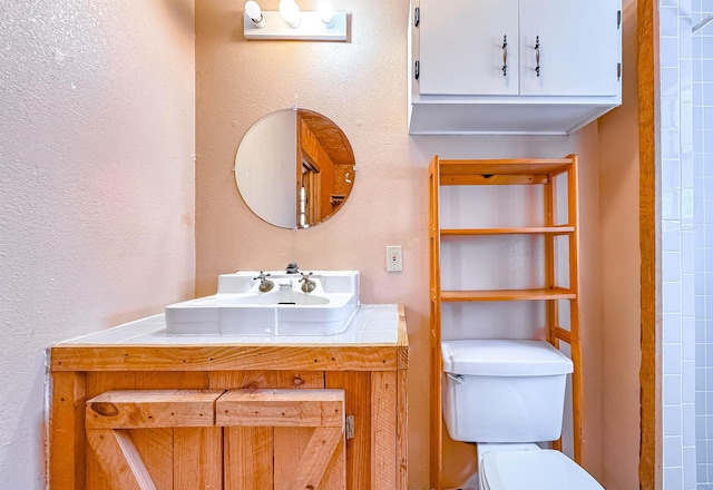 bathroom with vanity, toilet, and walk in shower