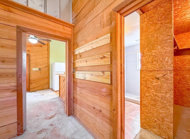 hallway featuring carpet floors and wooden walls