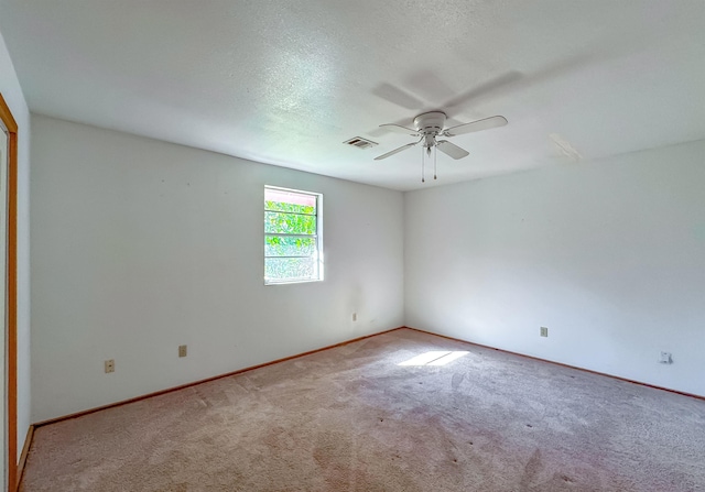 carpeted empty room featuring ceiling fan and a textured ceiling