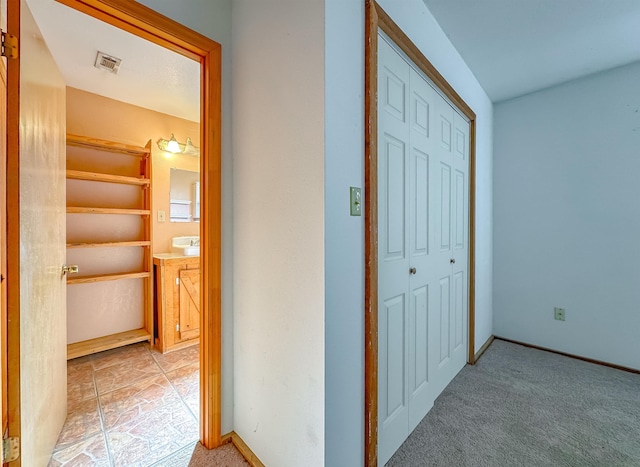 hallway featuring light colored carpet