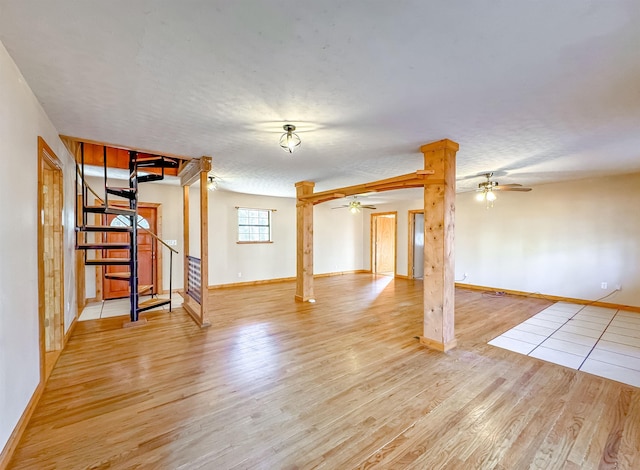 basement featuring ceiling fan, a textured ceiling, and light hardwood / wood-style flooring