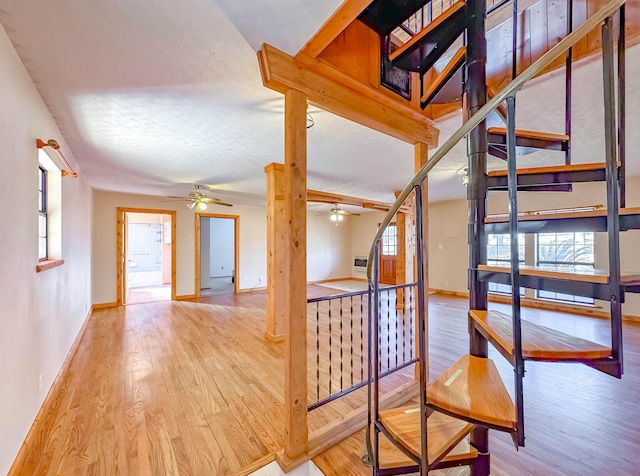 corridor with a textured ceiling and light hardwood / wood-style flooring