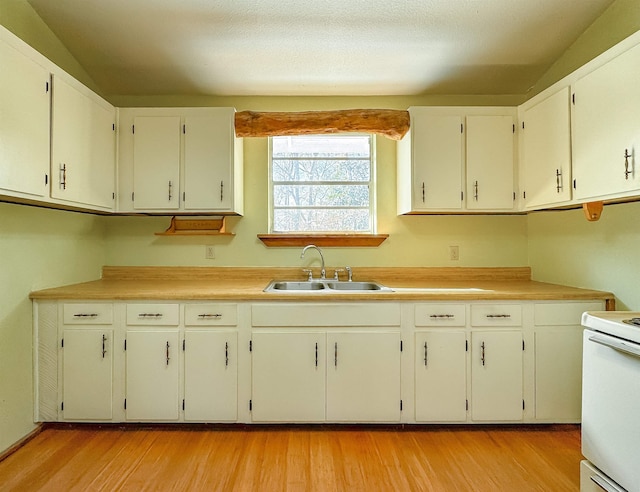 kitchen featuring white cabinets, light wood-type flooring, sink, and white stove