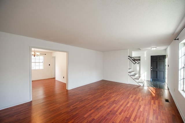 120 China Doll Dr, Tallahassee, FL 32312 - unfurnished living room featuring stairway, dark wood finished floors, and a chandelier