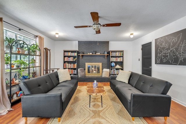 120 China Doll Dr, Tallahassee, FL 32312 - living area with wood finished floors, a textured ceiling, a ceiling fan, and a fireplace