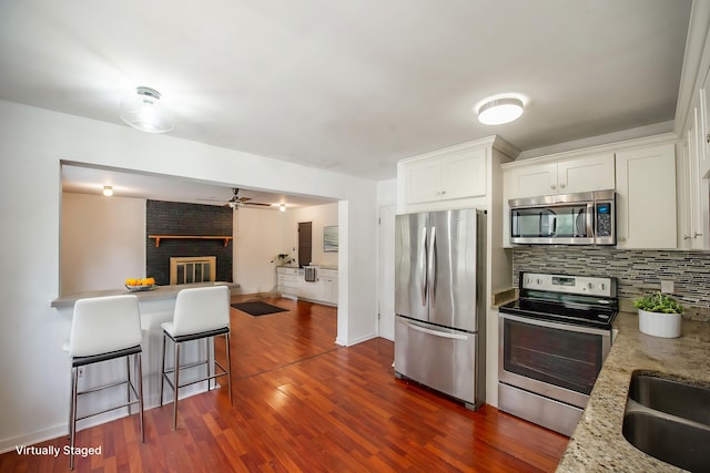 120 China Doll Dr, Tallahassee, FL 32312 - kitchen with stainless steel appliances, tasteful backsplash, white cabinetry, dark wood-style floors, and a ceiling fan