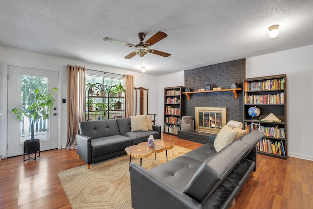 120 China Doll Dr, Tallahassee, FL 32312 - living room featuring a ceiling fan, a textured ceiling, wood finished floors, and a fireplace