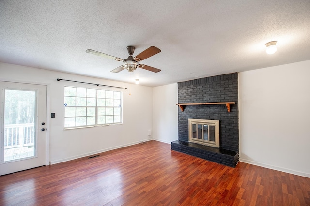 120 China Doll Dr, Tallahassee, FL 32312 - unfurnished living room with wood finished floors, ceiling fan, a textured ceiling, and a brick fireplace