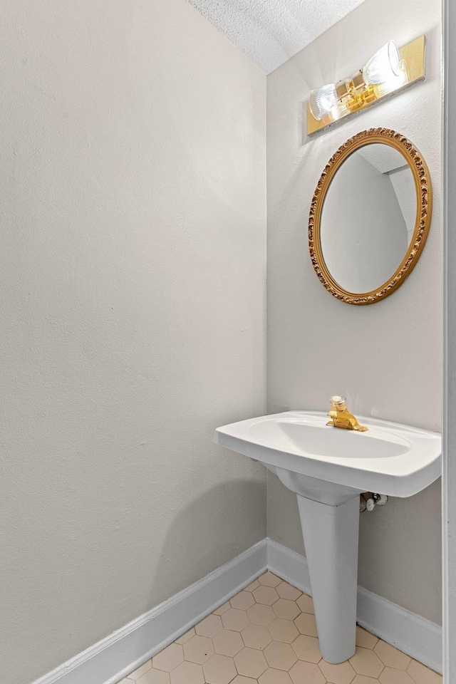 bathroom with tile patterned flooring and a textured ceiling