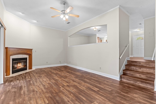 unfurnished living room with hardwood / wood-style floors, ceiling fan, ornamental molding, and a tiled fireplace