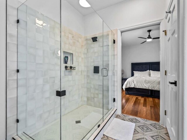 bathroom with an enclosed shower, wood-type flooring, and ceiling fan