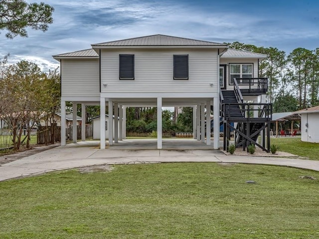 rear view of house featuring a lawn, a storage shed, and a carport