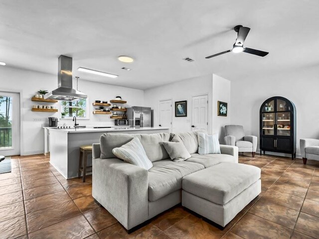 living room with ceiling fan and sink