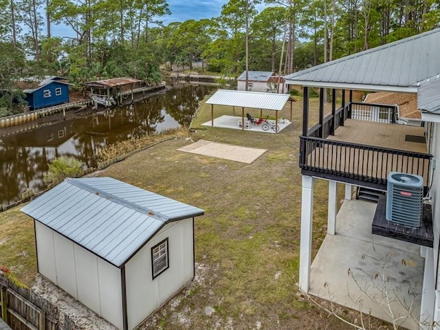 view of yard featuring a deck with water view, a patio, and central AC