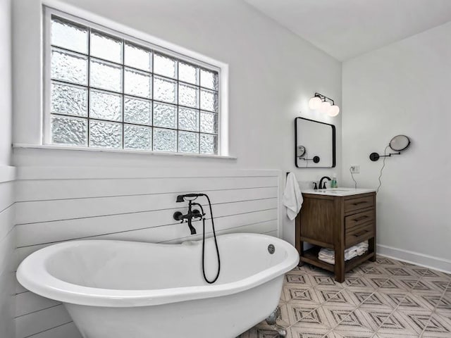 bathroom with a wealth of natural light, a bathtub, and vanity