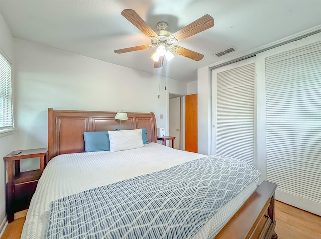 bedroom featuring a closet, light hardwood / wood-style flooring, and ceiling fan