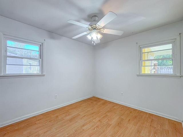 empty room with ceiling fan and light hardwood / wood-style flooring