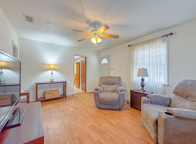 living room with light hardwood / wood-style flooring and ceiling fan