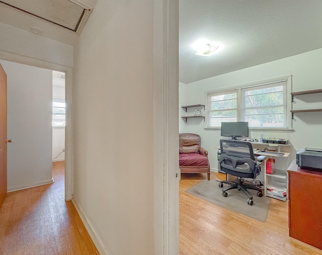 office space with light wood-type flooring and a textured ceiling