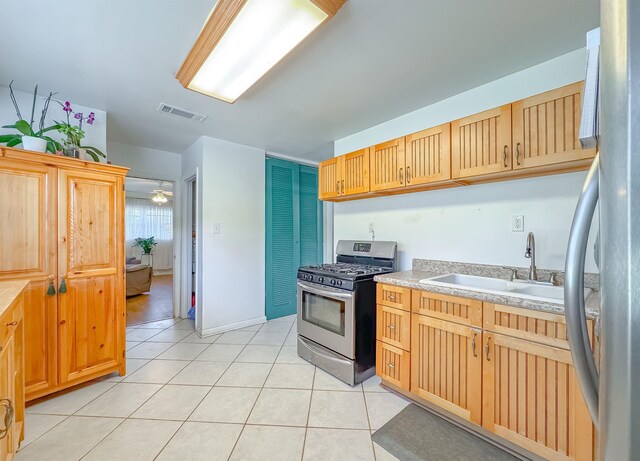 kitchen featuring sink, light tile patterned floors, and appliances with stainless steel finishes