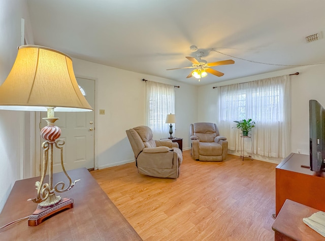 living area with hardwood / wood-style flooring, ceiling fan, and a healthy amount of sunlight