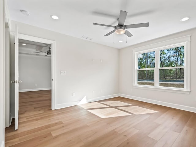 empty room with ceiling fan and light hardwood / wood-style flooring