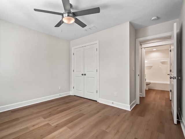 unfurnished bedroom featuring wood-type flooring, ceiling fan, and a closet