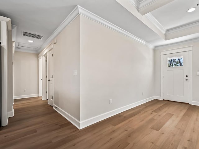 foyer featuring crown molding, wood-type flooring, and a raised ceiling